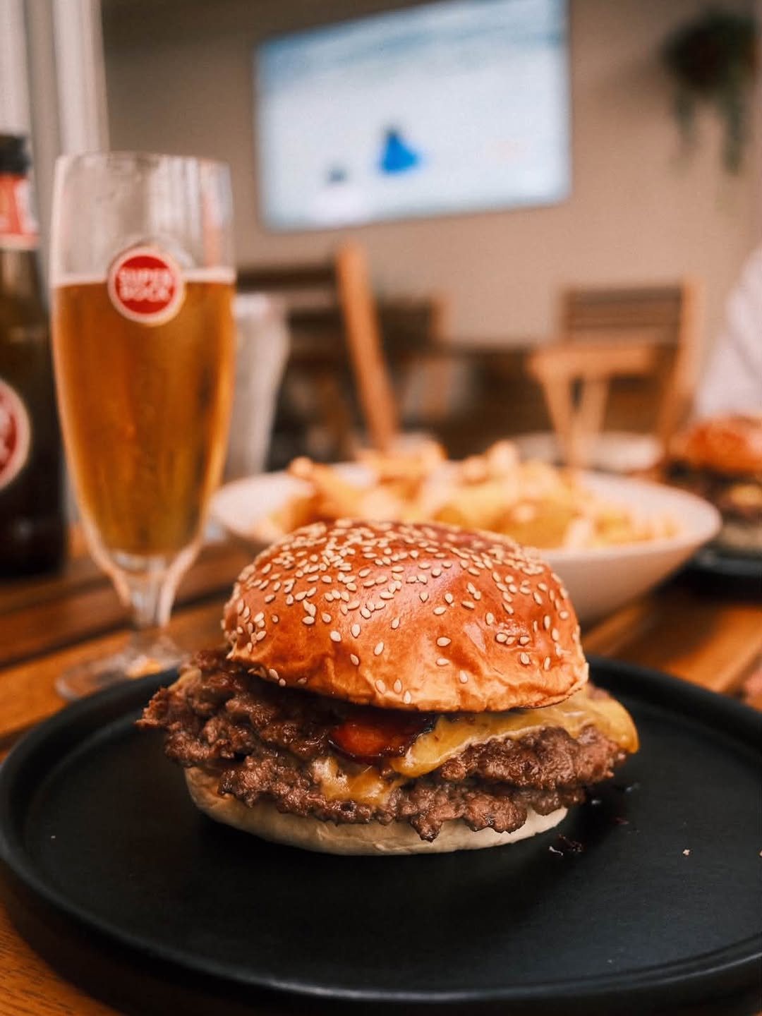 Smash burger do O Cultural com batatas e cerveja